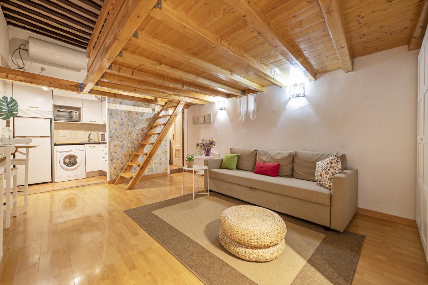 loft-apartment-with-pine-wood-paneling-white-furniture-ground-floor-matching-wooden-staircase-parquet-floors-with-beige-rug-small-open-plan-kitchen